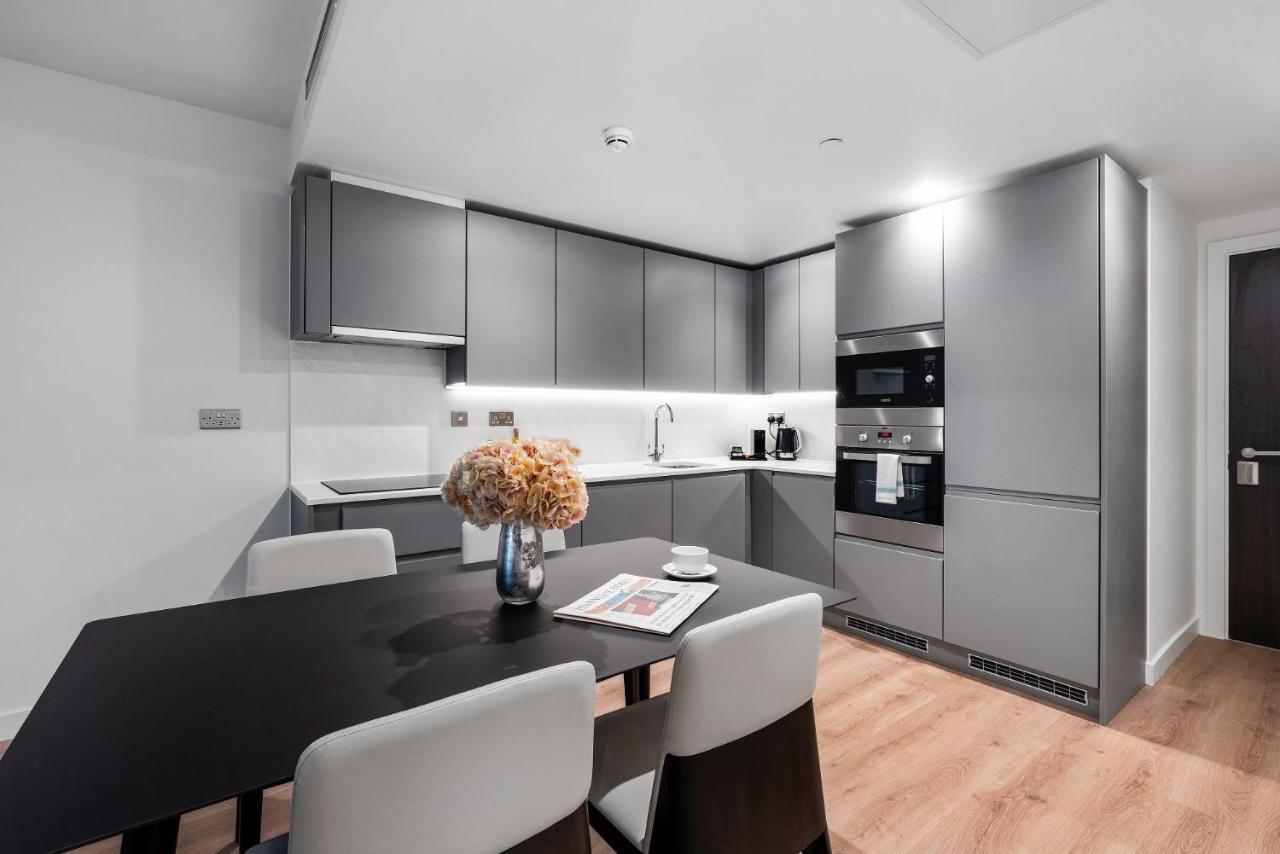 Citysuites 2 Aparthotel Manchester Exteriör bild The photo shows a modern kitchen space. It features sleek, gray cabinetry with a minimalist design. There is a countertop with a sink, and appliances including an oven and a coffee maker. A dining table is positioned near the kitchen area, accompanie